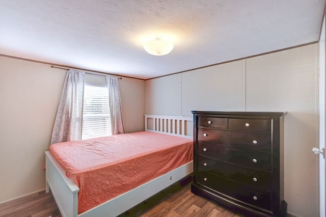 bedroom with wood finished floors and a textured ceiling