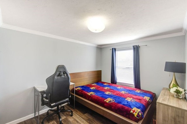 bedroom featuring a textured ceiling, wood finished floors, baseboards, and ornamental molding