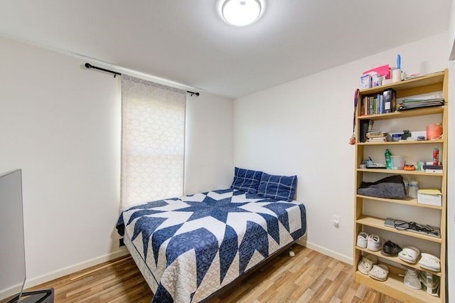 bedroom featuring baseboards and wood finished floors