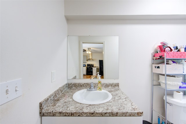 bathroom with a ceiling fan, toilet, and vanity