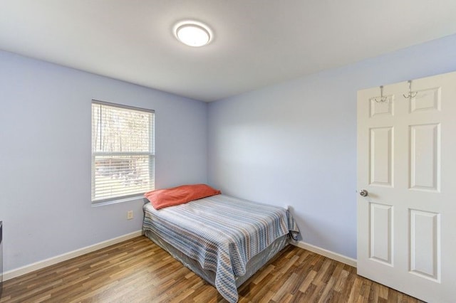 bedroom with wood finished floors and baseboards