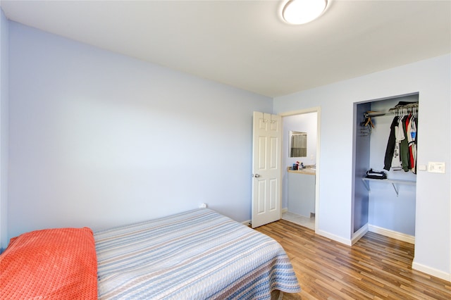 bedroom with light wood finished floors, baseboards, and a closet