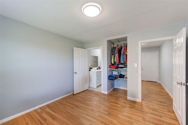 unfurnished bedroom with light wood finished floors, a closet, and baseboards