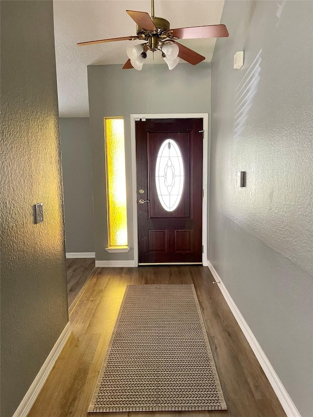 entrance foyer featuring baseboards, a textured ceiling, wood finished floors, and a ceiling fan