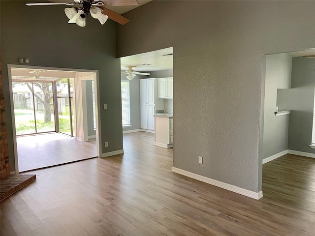 interior space featuring baseboards, light wood-type flooring, and a ceiling fan