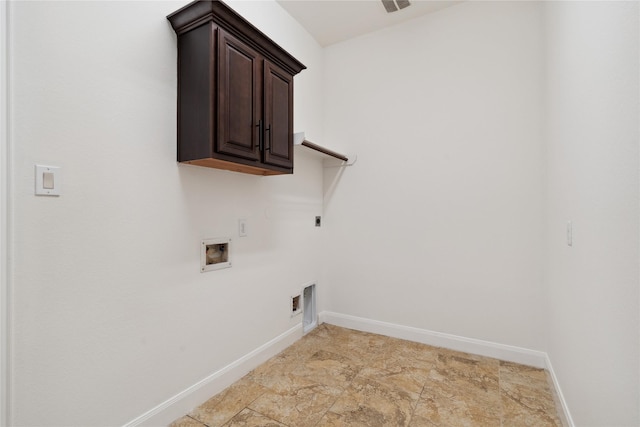 clothes washing area featuring hookup for a washing machine, baseboards, cabinet space, electric dryer hookup, and stone finish flooring