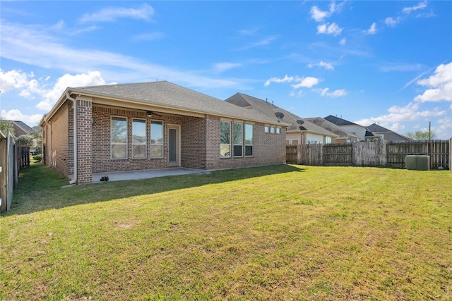 rear view of property with a lawn, a fenced backyard, brick siding, ceiling fan, and a patio area