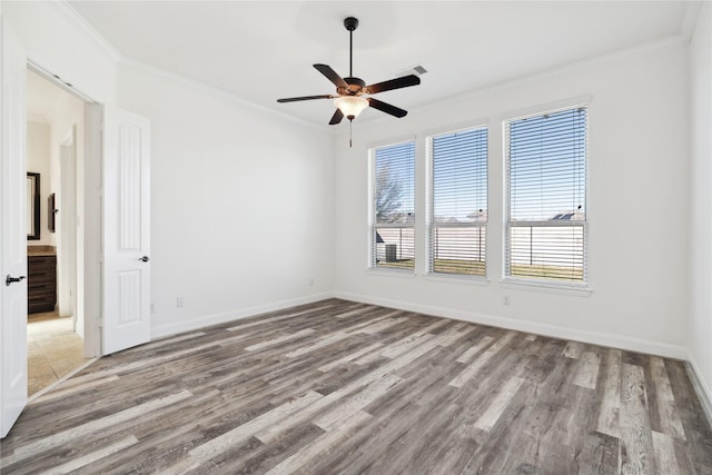 unfurnished room featuring baseboards, a ceiling fan, wood finished floors, and crown molding