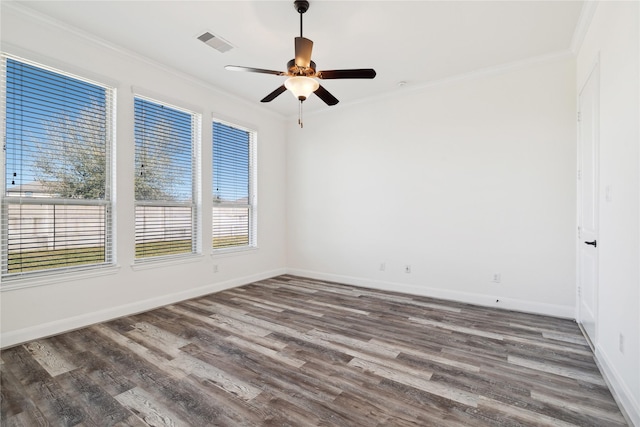 spare room featuring visible vents, crown molding, baseboards, ceiling fan, and wood finished floors