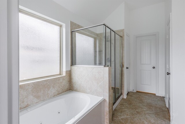 full bathroom with a tub with jets, a shower stall, and tile patterned flooring