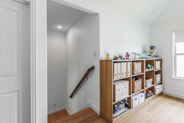 stairway with wood finished floors and baseboards