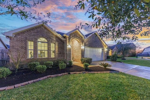 view of front of property featuring concrete driveway, a garage, a lawn, and brick siding