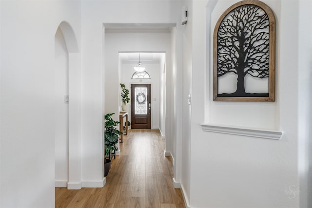 foyer with light wood-style flooring and baseboards