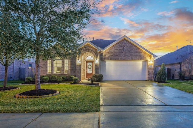 view of front of property with brick siding, fence, concrete driveway, a lawn, and a garage