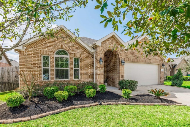 view of front of house with a garage, fence, brick siding, and driveway