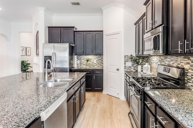 kitchen featuring visible vents, light wood-type flooring, a sink, appliances with stainless steel finishes, and light stone countertops