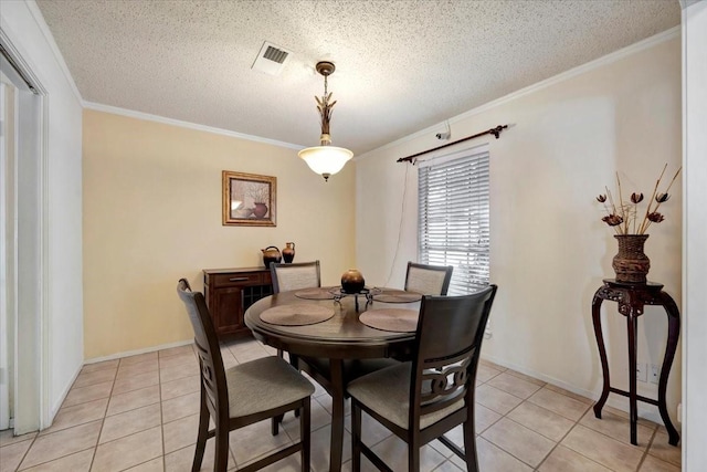 dining space with visible vents, a textured ceiling, light tile patterned flooring, and crown molding