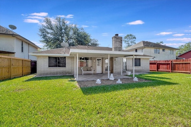 back of house with a yard, a fenced backyard, and brick siding