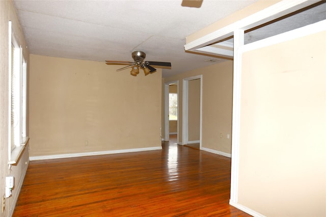 spare room featuring visible vents, baseboards, a ceiling fan, and wood finished floors