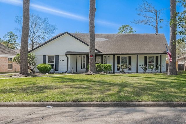 view of front of property with central AC, covered porch, roof with shingles, a front yard, and brick siding