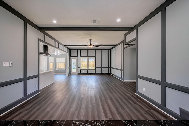 spare room with visible vents, baseboards, ceiling fan, dark wood finished floors, and beam ceiling