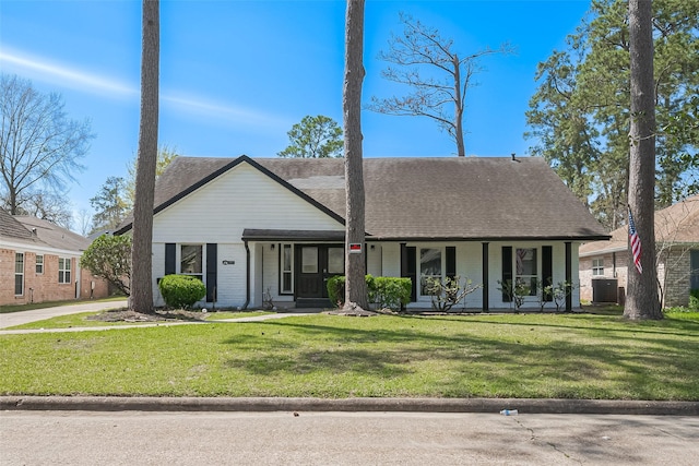 view of front facade with a front lawn, brick siding, central AC, and roof with shingles