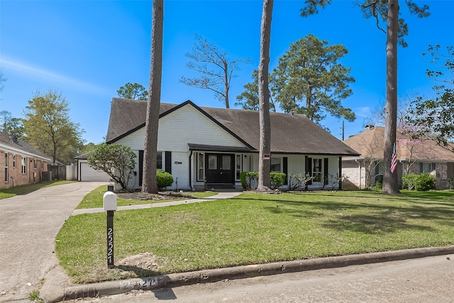 view of front of house with a front yard, driveway, a shingled roof, a garage, and brick siding