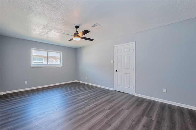 empty room featuring a ceiling fan, visible vents, baseboards, dark wood-type flooring, and a textured ceiling