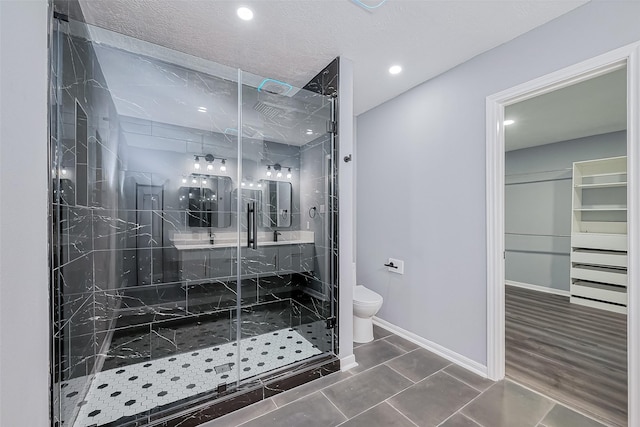 full bathroom featuring baseboards, toilet, a stall shower, and vanity