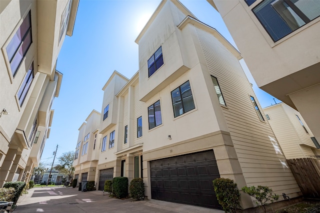 view of building exterior with an attached garage and a residential view