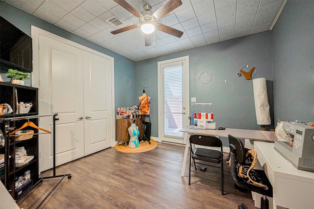 home office featuring a ceiling fan, visible vents, wood finished floors, and baseboards