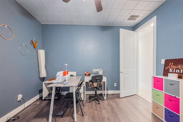 home office featuring ceiling fan, visible vents, baseboards, and wood finished floors