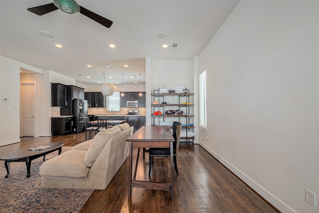 living area featuring dark wood-type flooring, plenty of natural light, visible vents, and ceiling fan