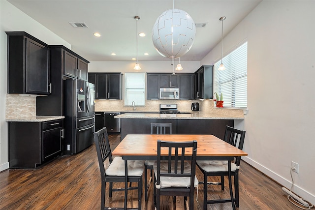 kitchen with dark cabinets, dark wood-style floors, visible vents, and appliances with stainless steel finishes