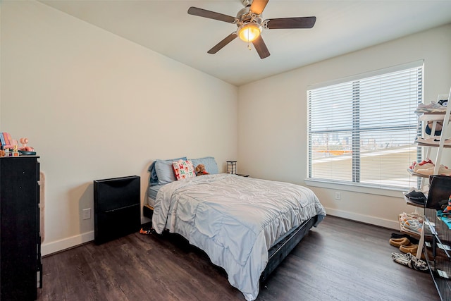 bedroom with dark wood-type flooring, a ceiling fan, and baseboards