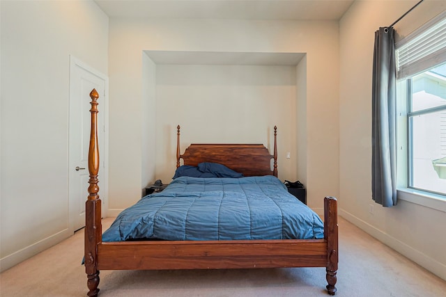 bedroom featuring light colored carpet and baseboards