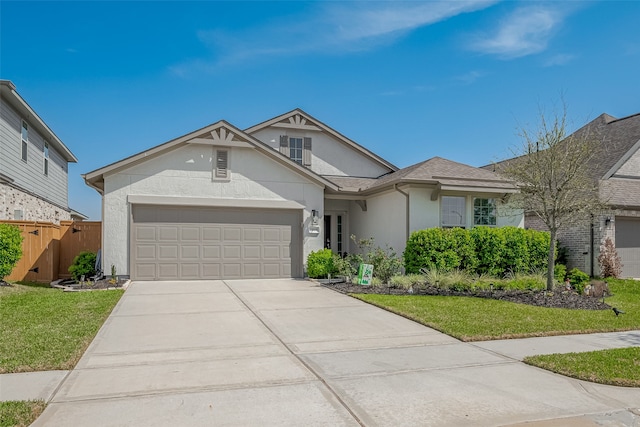 view of front of house with stucco siding, fence, concrete driveway, a front yard, and a garage