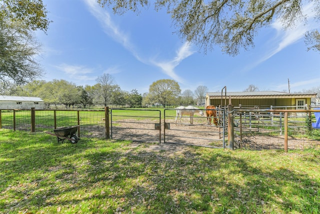 view of yard featuring an outbuilding, a rural view, and an exterior structure