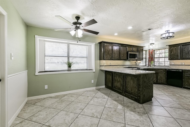 kitchen with light tile patterned floors, a peninsula, ceiling fan, dishwasher, and stainless steel microwave