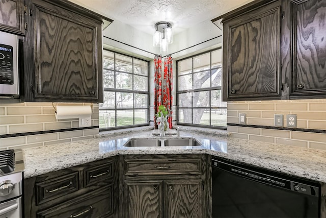 kitchen featuring a textured ceiling, black dishwasher, backsplash, and a sink