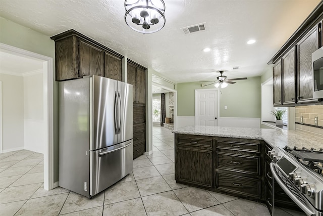 kitchen featuring light stone counters, light tile patterned floors, visible vents, a peninsula, and appliances with stainless steel finishes