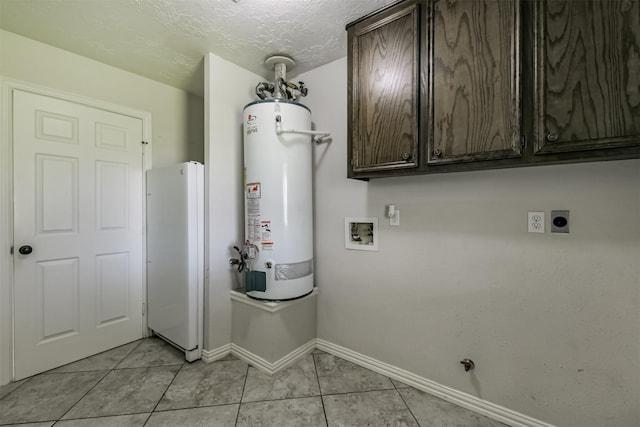 clothes washing area with gas water heater, cabinet space, light tile patterned floors, hookup for an electric dryer, and hookup for a washing machine