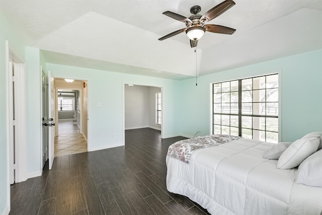 bedroom with vaulted ceiling, ceiling fan, baseboards, and dark wood-style flooring