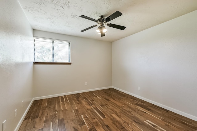 spare room with a textured ceiling, wood finished floors, baseboards, and ceiling fan