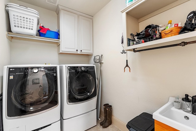 laundry room featuring visible vents, baseboards, cabinet space, separate washer and dryer, and a sink