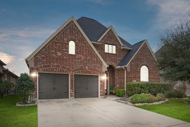 view of front of home featuring brick siding, concrete driveway, roof with shingles, and a front yard