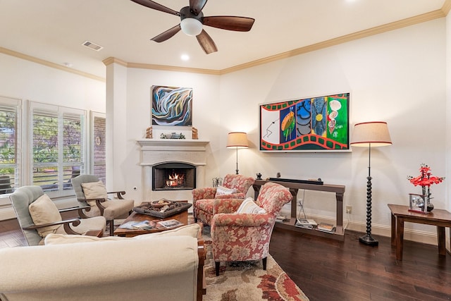 living room featuring visible vents, baseboards, ceiling fan, a lit fireplace, and hardwood / wood-style floors