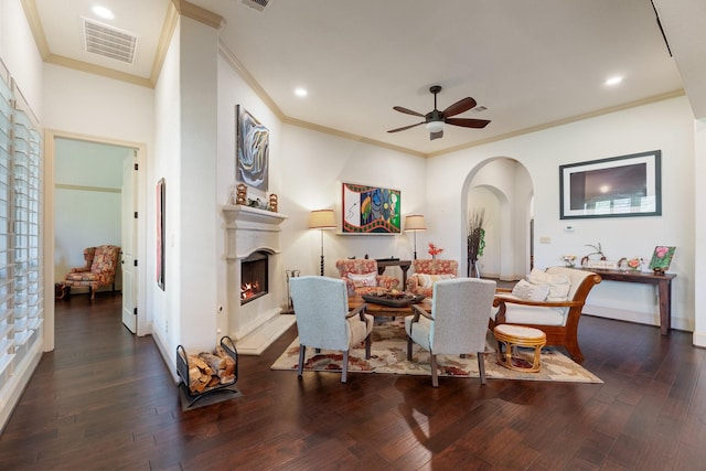 dining space with arched walkways, visible vents, a warm lit fireplace, and wood finished floors