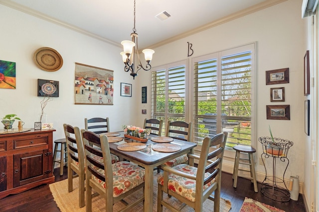 dining room featuring a chandelier, visible vents, ornamental molding, and dark wood-style flooring