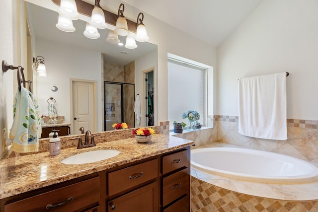 bathroom featuring vanity, a garden tub, a stall shower, and vaulted ceiling